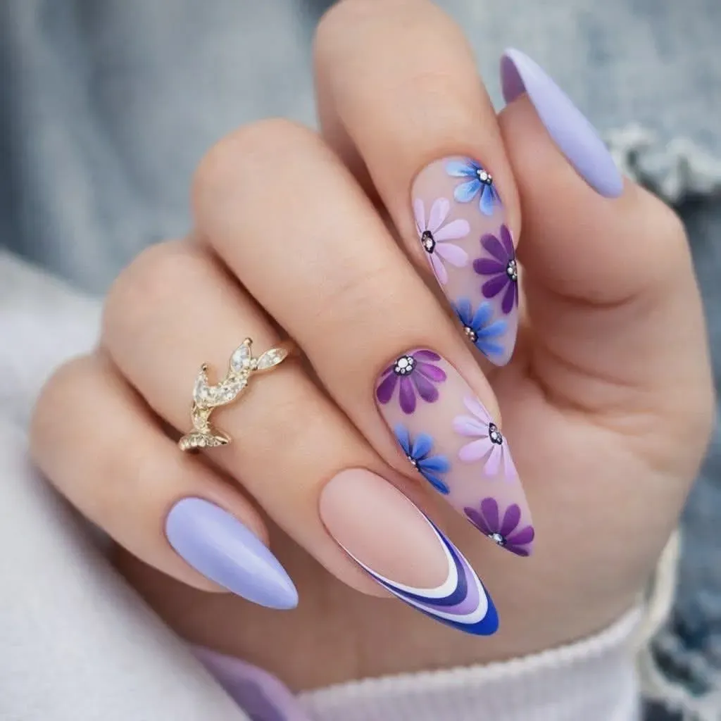 Closeup von Nail Art in blauen Farbtönen mit Blumen und geschwungenen Details.